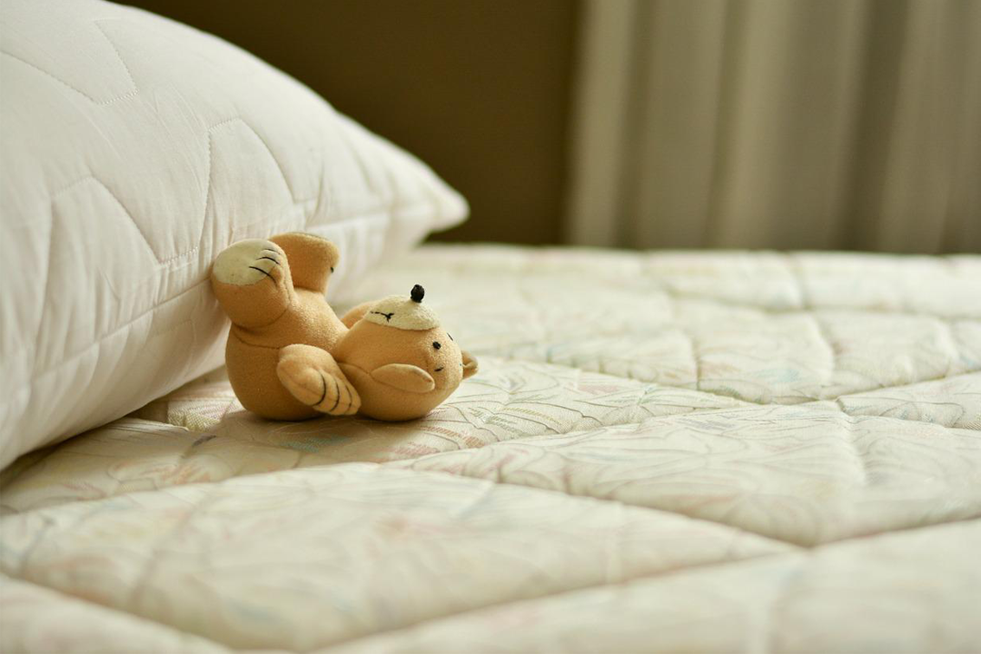 oso de peluche arriba del colchón